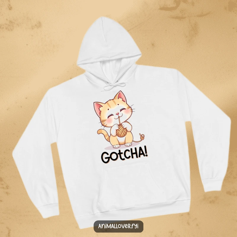 Funny hoodie featuring a curious cat engrossed in batting a dangling ball of yarn, perfect for cozy cat lovers.