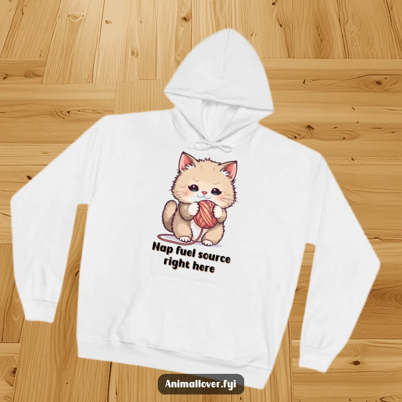 Funny hoodie graphic of a fluffy cat playfully tangled in a giant ball of yarn, radiating joy and humor.