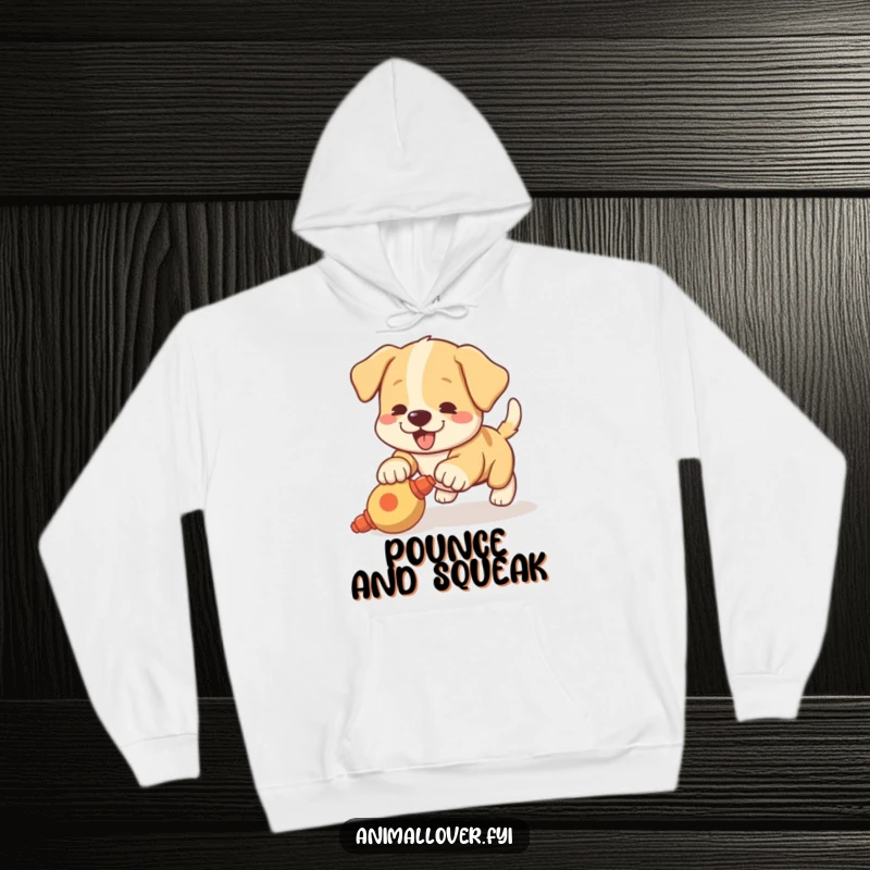 Funny hoodie featuring an excited puppy with a wagging tail pouncing enthusiastically on a squeaky toy, very cozy.