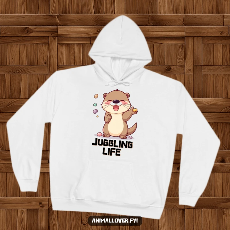 Funny Hoodie: A delighted otter energetically juggling shiny pebbles, exuding fun and happiness.