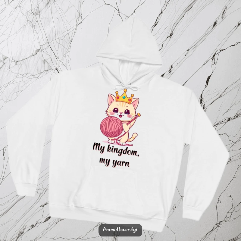 Funny hoodie showcasing a cute cat wearing a crown, triumphantly clutching a massive yarn ball.