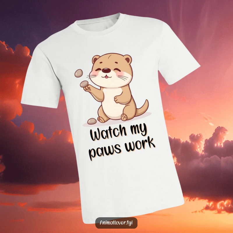 Funny otter t-shirt, a curious otter skillfully juggles smooth stones, showcasing playful dexterity and charm.