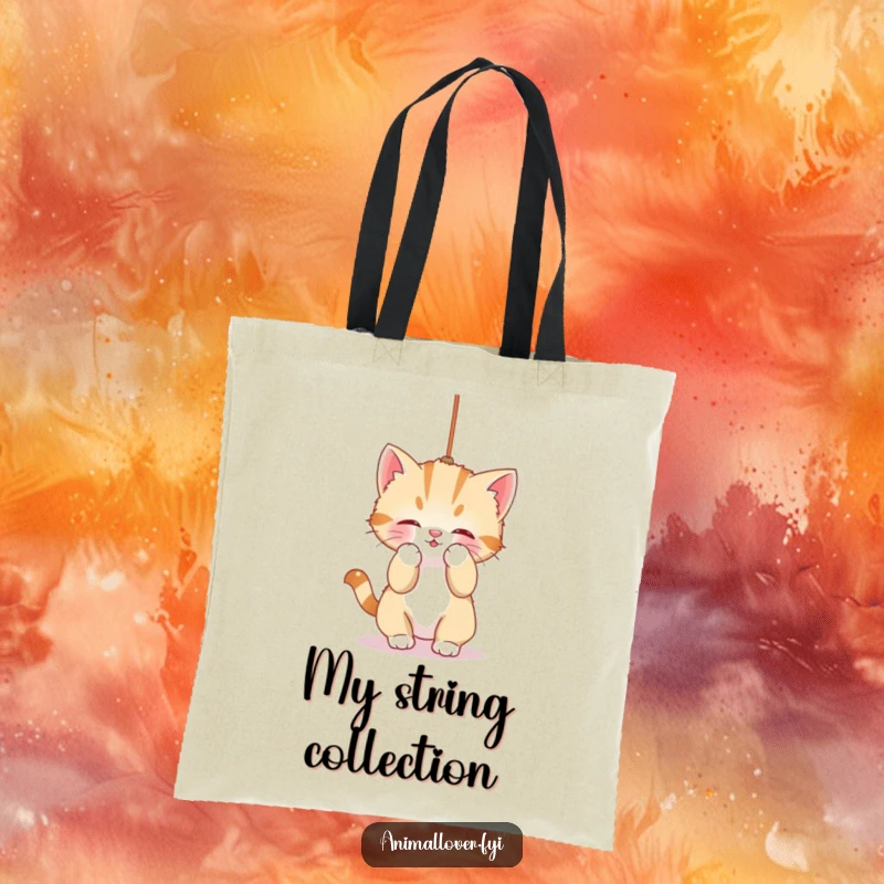 Funny Tote Bag: A cute kitten is captured mid-bat at a dangling string, embodying playful mischief and charm.